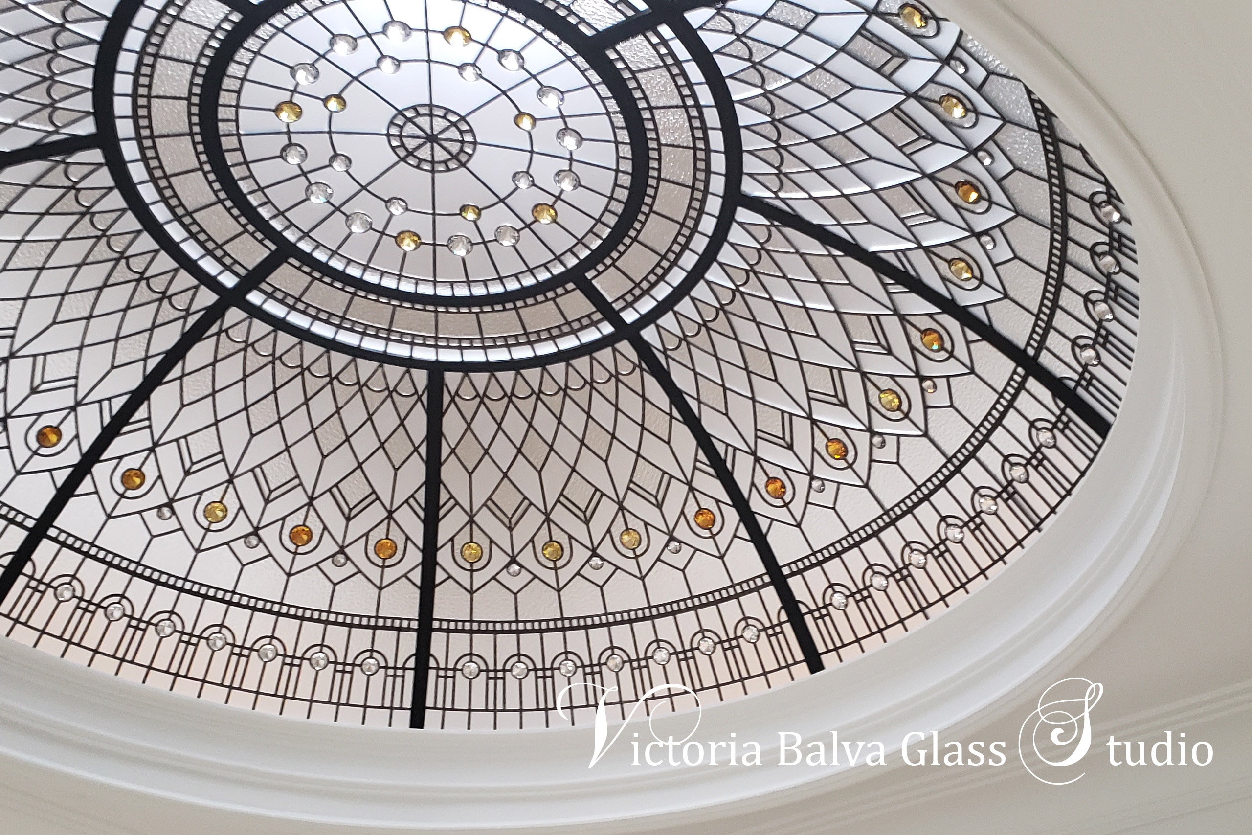 Custom stained glass dome skylight for a grand entryway foyer of the custom built house in Brampton. Clear textured glasses with pale coloured jewels make this stained glass dome design a crown jewel of the house